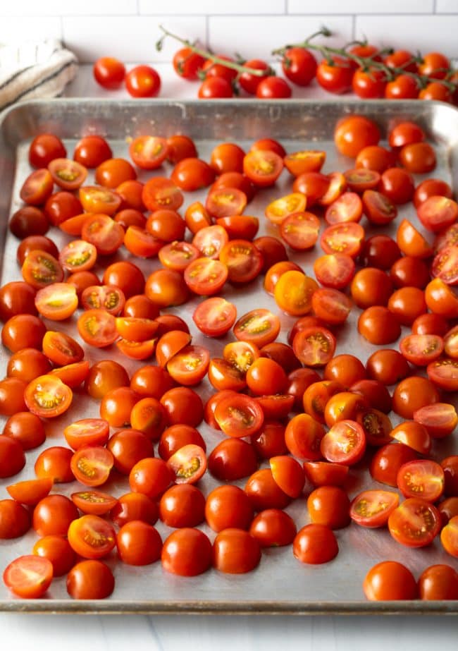 Fresh halved tomatoes on a baking sheet.