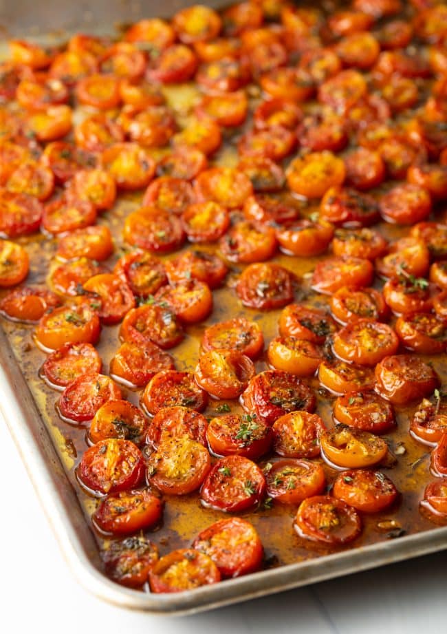 Toasted cherry tomatoes on a baking sheet.