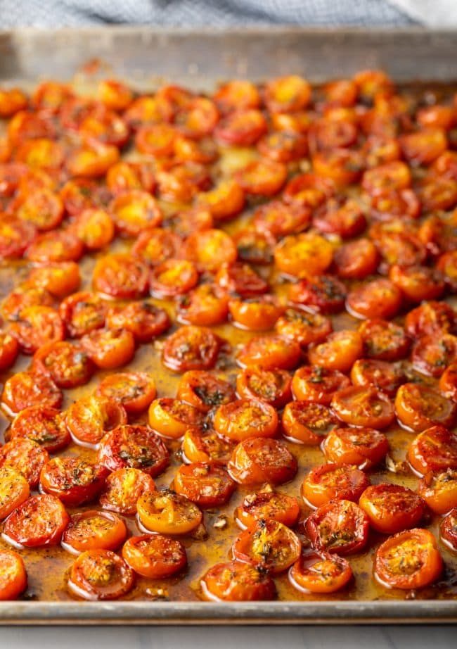 Side view of oven roasted tomatoes on baking sheet.
