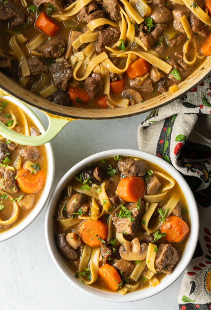 Top down bowl of noodle soup with meat and veggies.