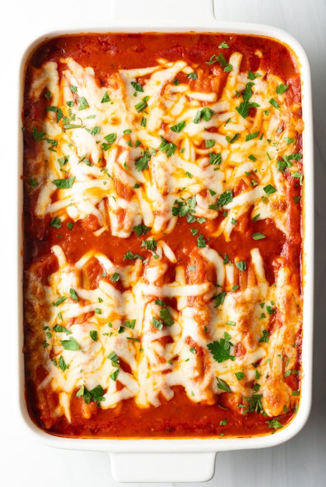 Top down view of Manicotti Recipe with Meat garnished with chopped fresh parsley.