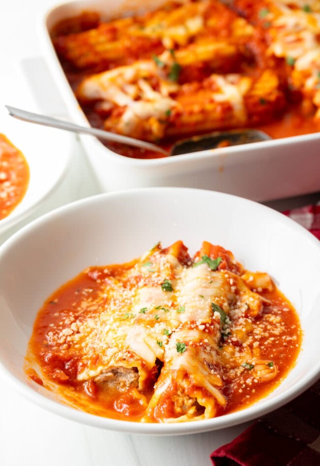 Two pieces of Manicotti Recipe with Meat in a white pasta bowl.