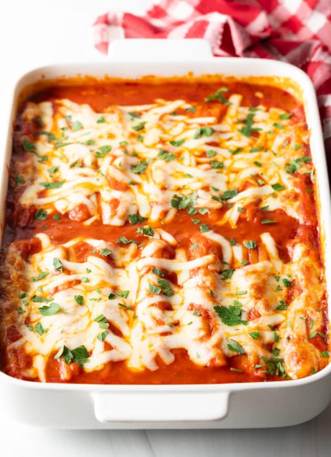 Top down view of baked Manicotti Recipe with Meat garnished with chopped fresh parsley.