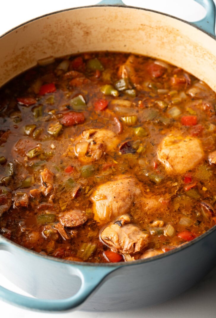 Cooking pieces of chicken in a large pot with stock.