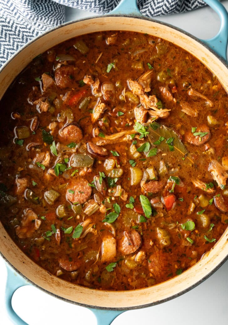 Large cooking pot of gumbo with chicken and sausage.