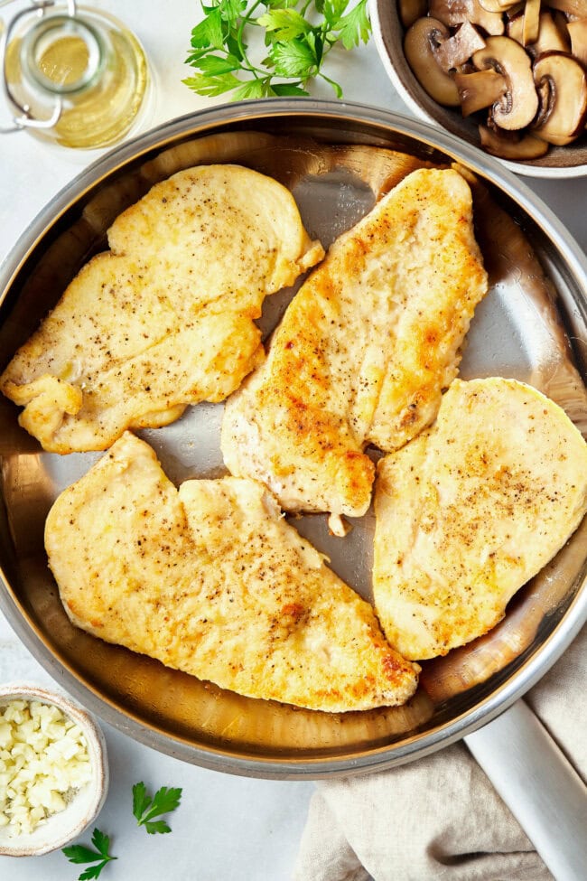 Cooking chicken in a large skillet. 