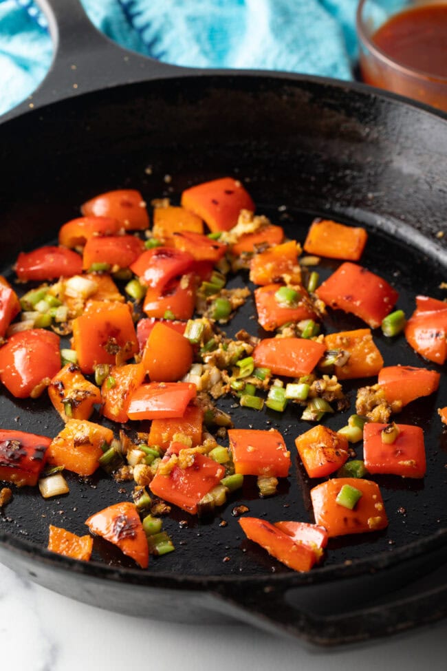 Chopped red peppers and garlic in a skillet.