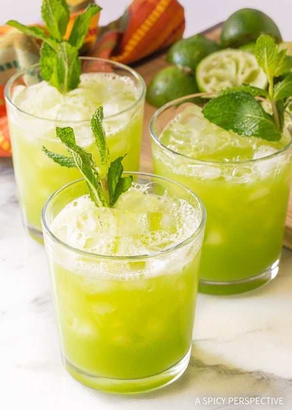 Three glasses of cucumber mint ginger agua fresca, garnished with mint.