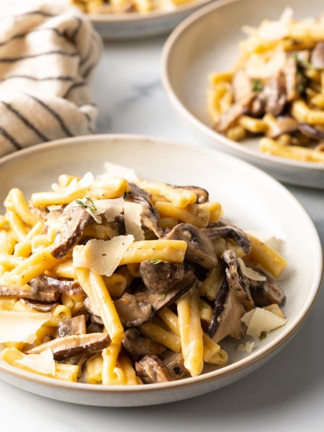 close up view of bowl with gemelli pasta and mushroom cream sauce