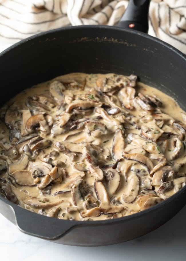 skillet with mushroom, herbs, and heavy cream