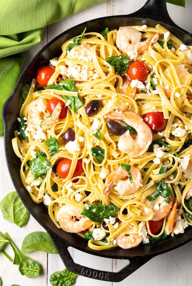 Overhead shot of greek shrimp pasta in a cast iron skillet. 
