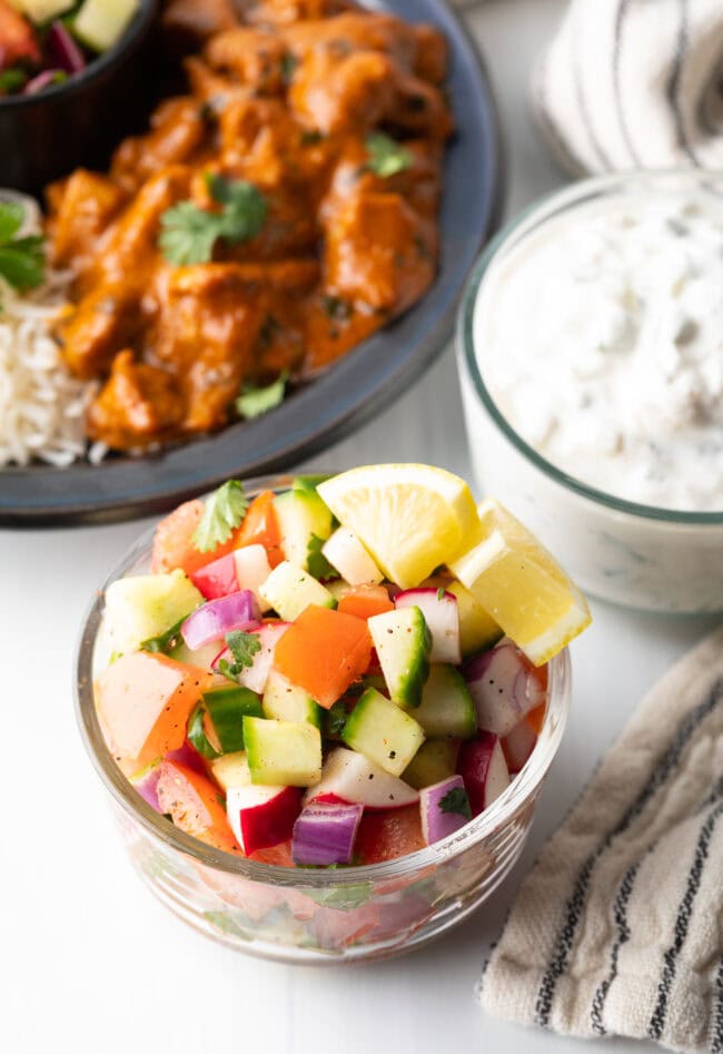 Chopped kachumber Indian cucumber salad in a glass bowl.
