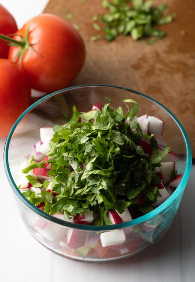 Fresh chopped herbs added to the bowl with veggies.