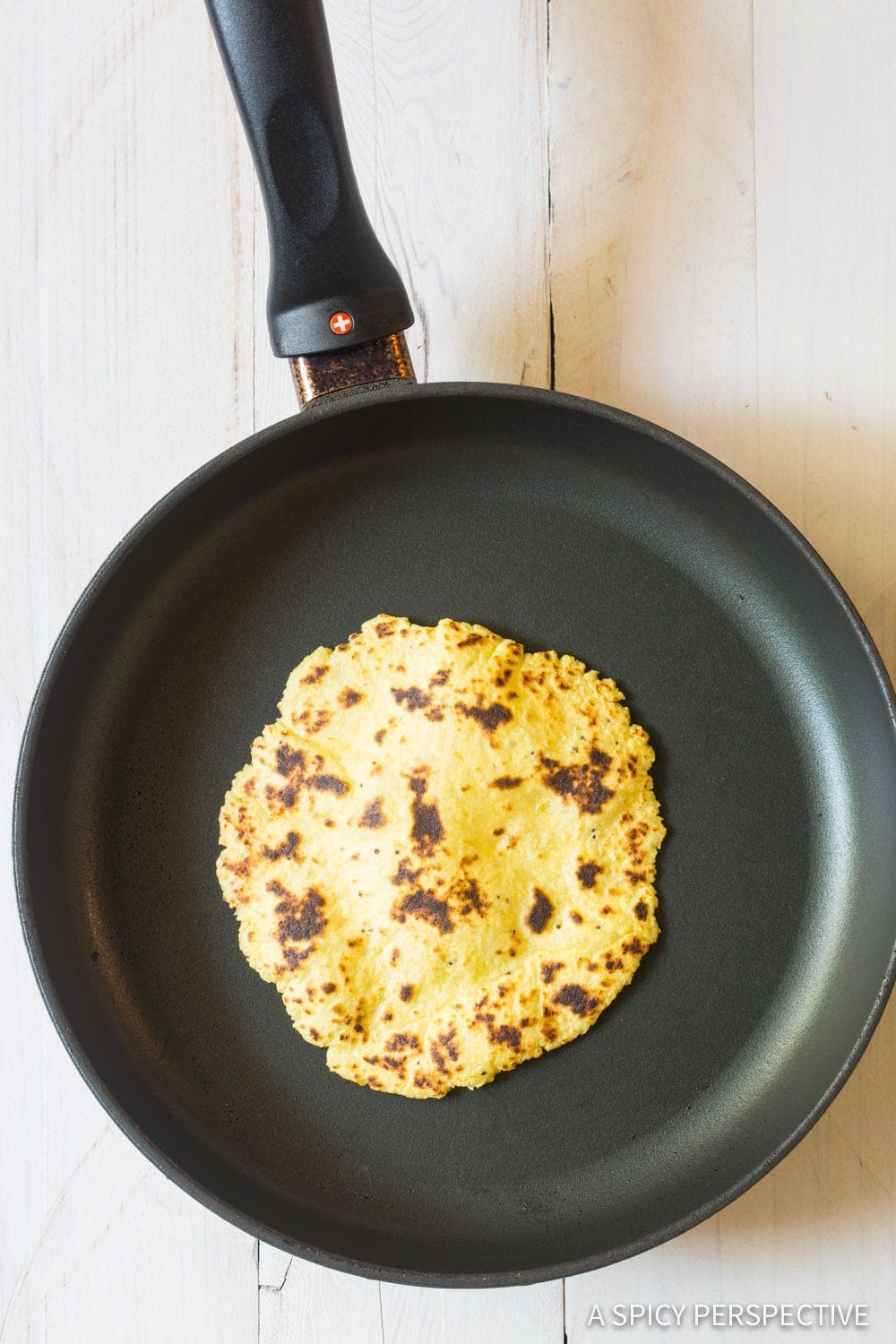 A plantain tortilla in a skillet.