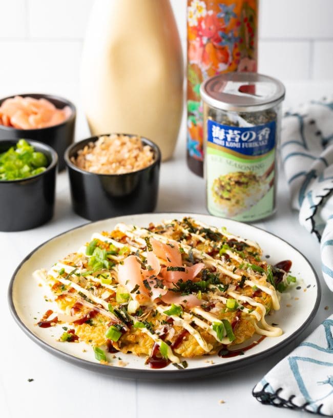 Okonomiyaki Recipe - finished Japanese pancakes loaded with toppings on a plate