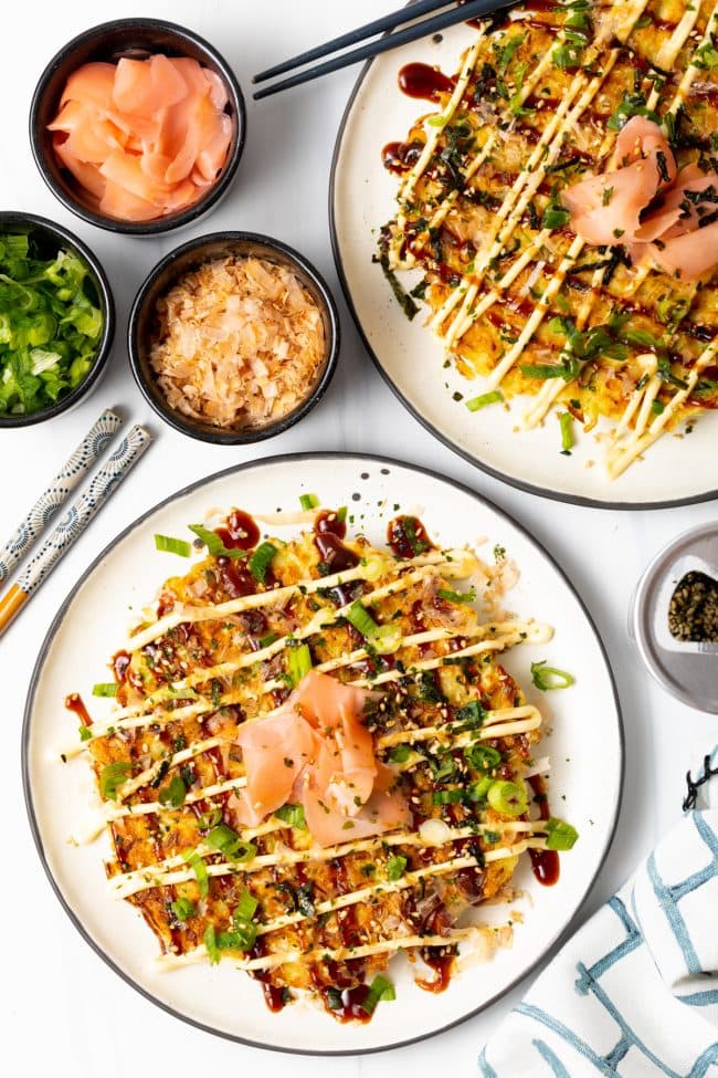 top view two plates with shredded cabbage Japanese Pancakes Okonomiyaki