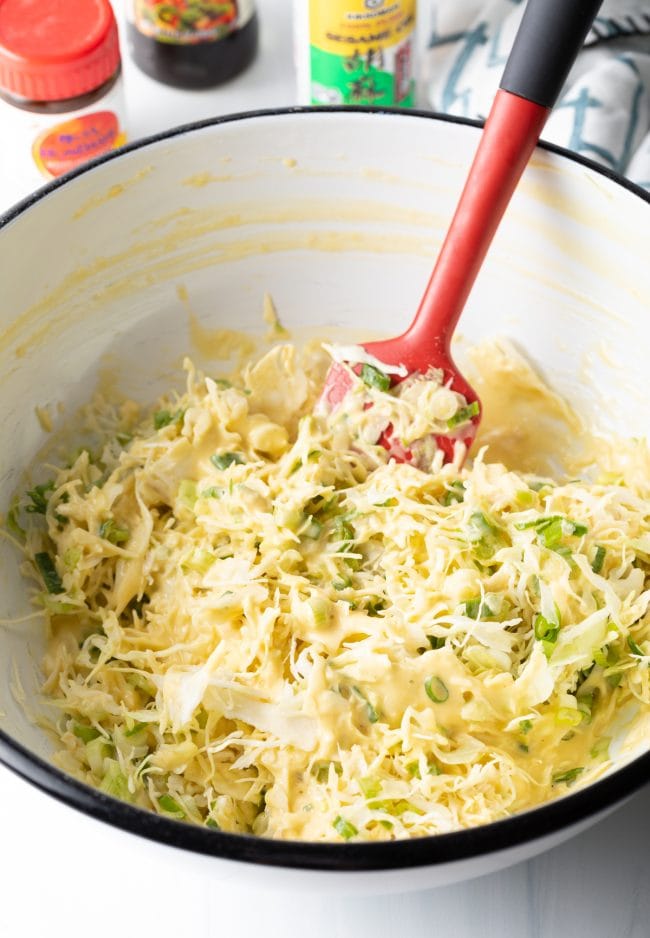 folding the shredded cabbage and scallions into the japanese pancakes batter