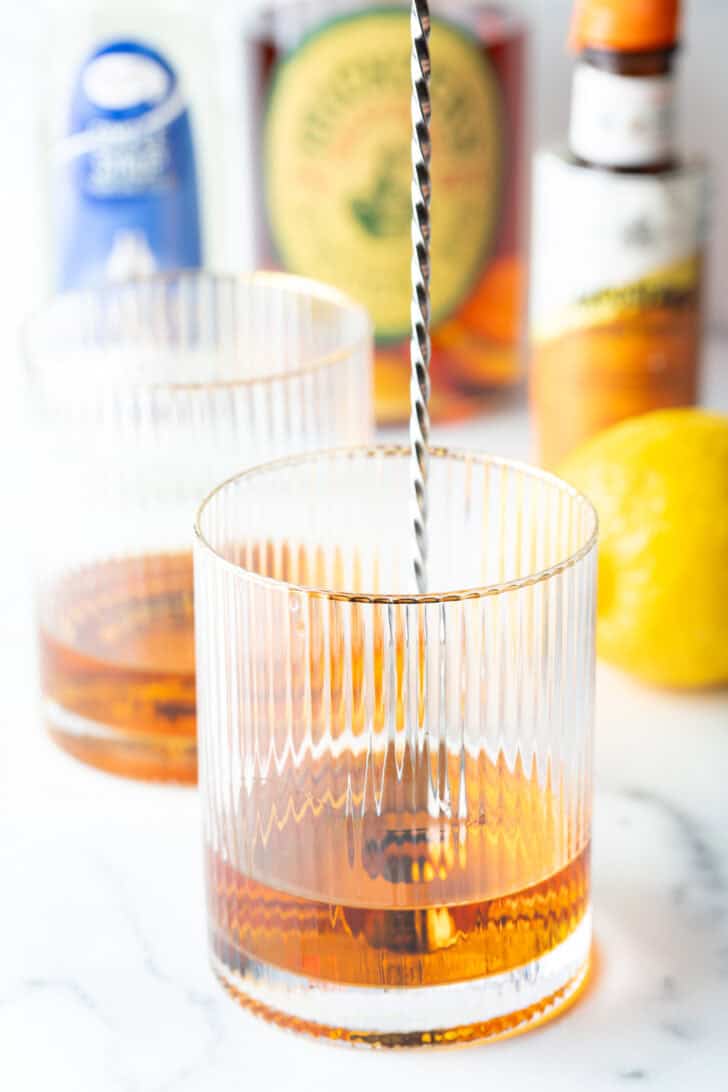 Metal stirrer in a lowball glass with bourbon.