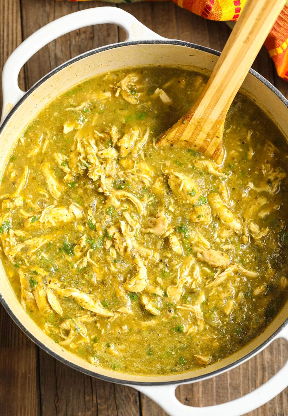 Top view of Chicken Chili Verde Recipe - a sauce pot with the soup and a wooden spoon
