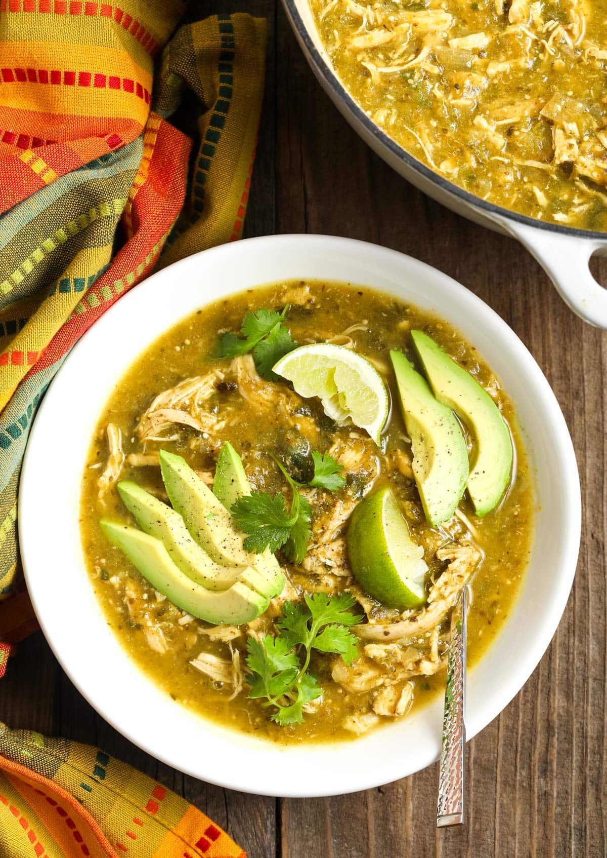 Top view of this chili verde in a bowl topped with some avocado and cilantro