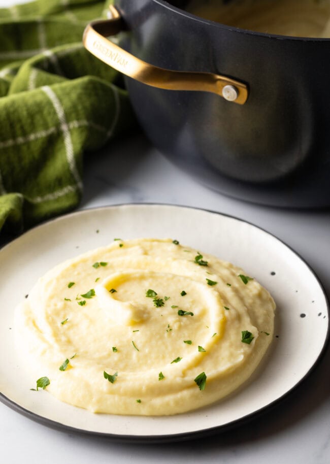 White plate with serving of rich and smooth pomme puree.
