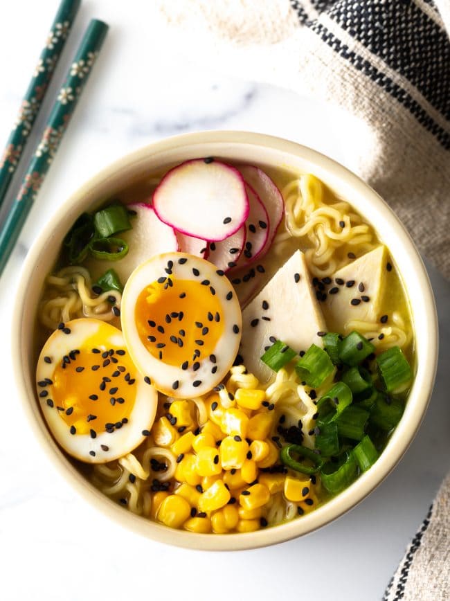 How To Make Ramen Eggs - ramen bowl loaded with noodles, tofu, eggs, corn, and radishes