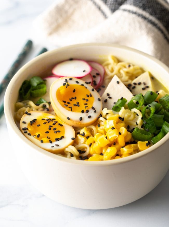 close up view of ajitsuke tamago nestled into a bowl of noodle soup