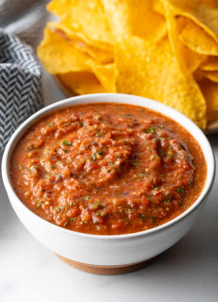 White bowl of red roasted tomato salsa.