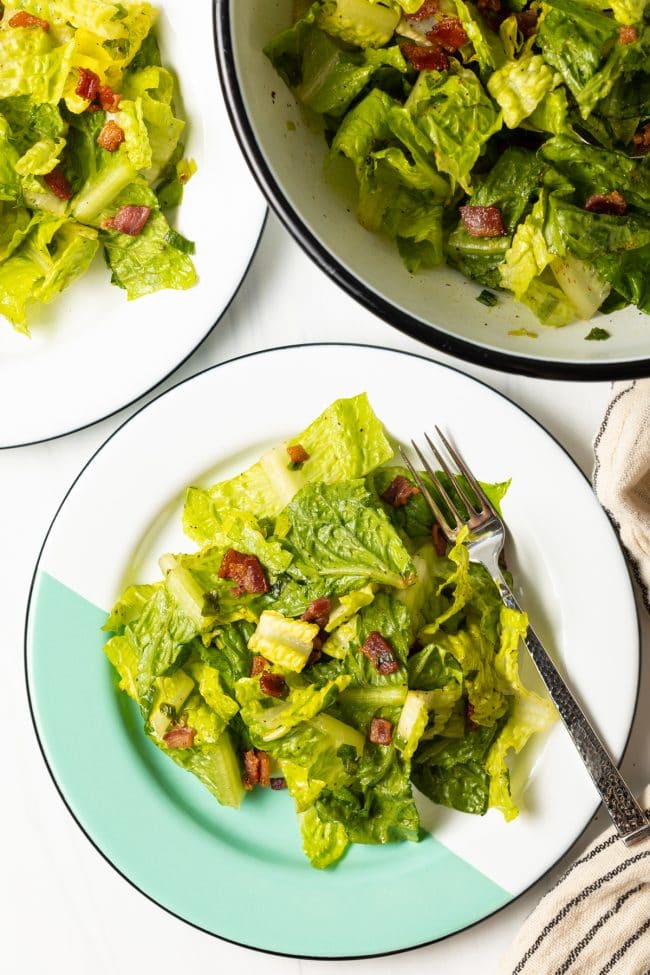 top view two plates with southern lettuce salad with a form and salad bowl in the background
