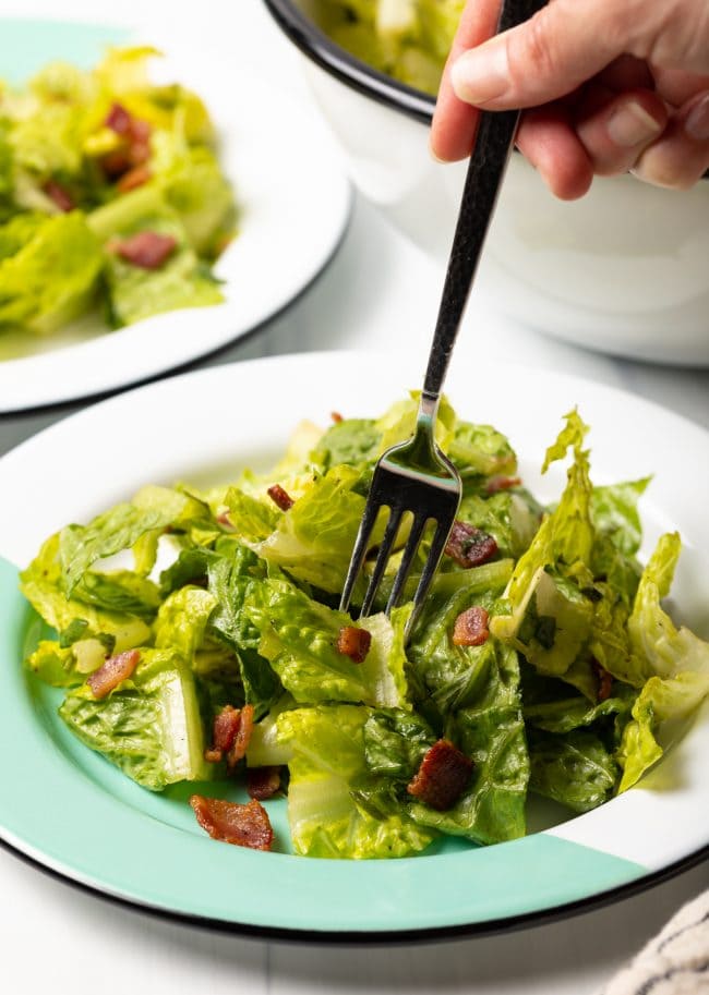 fork taking a bite of wilted lettuce salad recipe