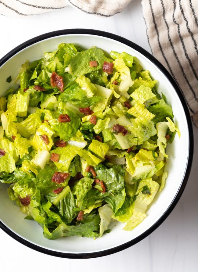 top view salad bowl with chopped romaine lettuce and warm bacon dressing