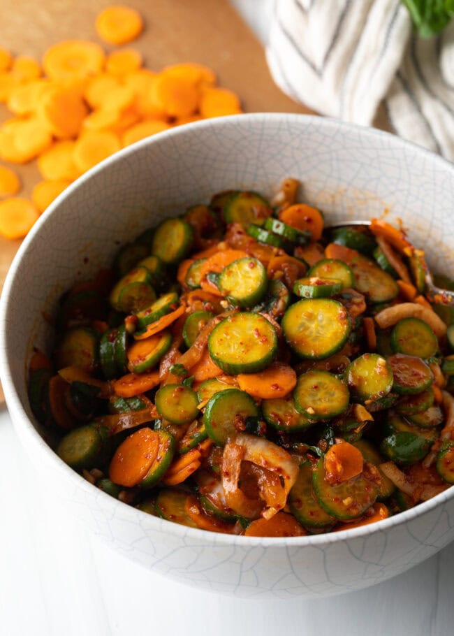 Salad with Korean marinated veggies tossed together in a white bowl.