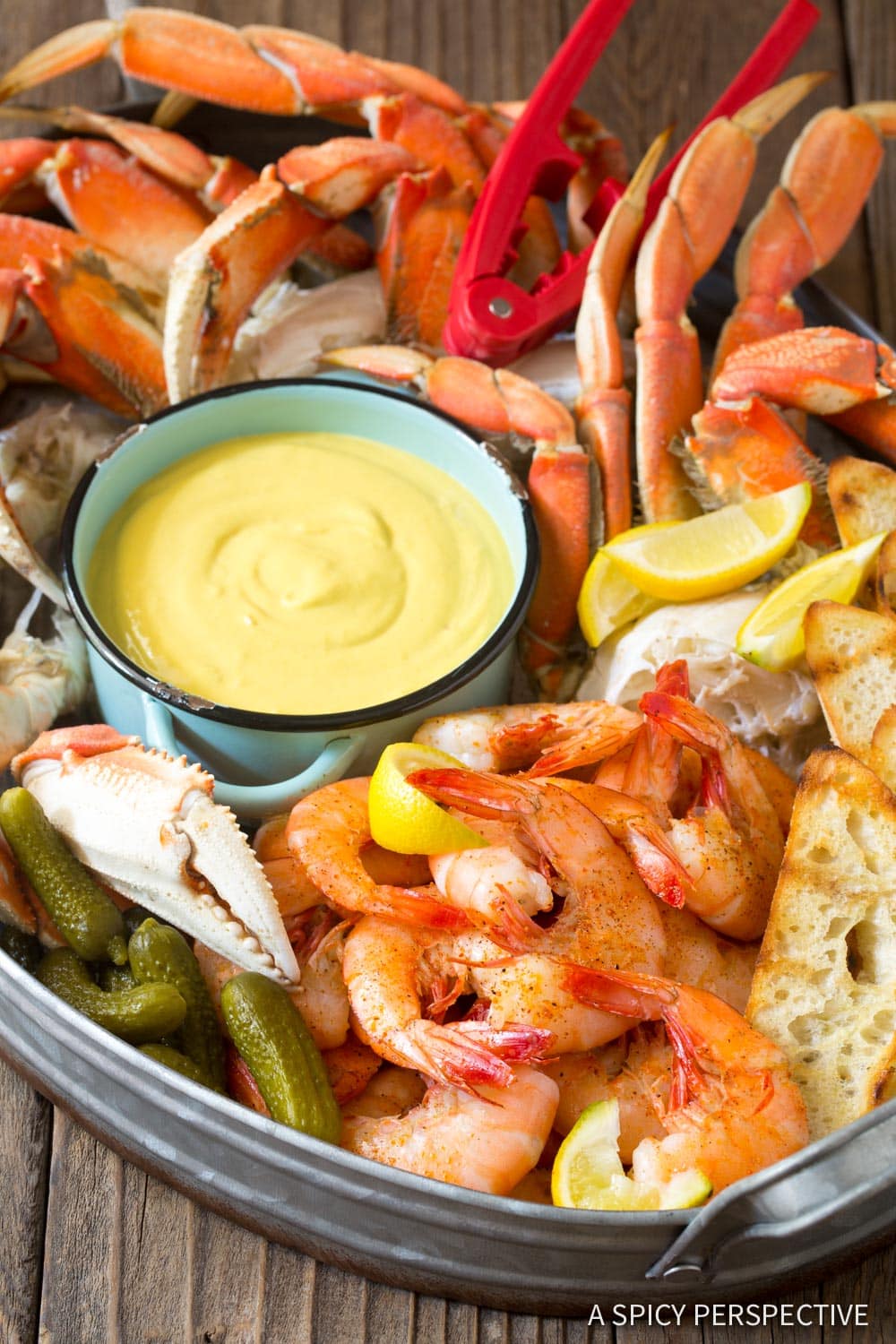 Seafood platter with a small bowl of seafood dipping sauce in the middle. 