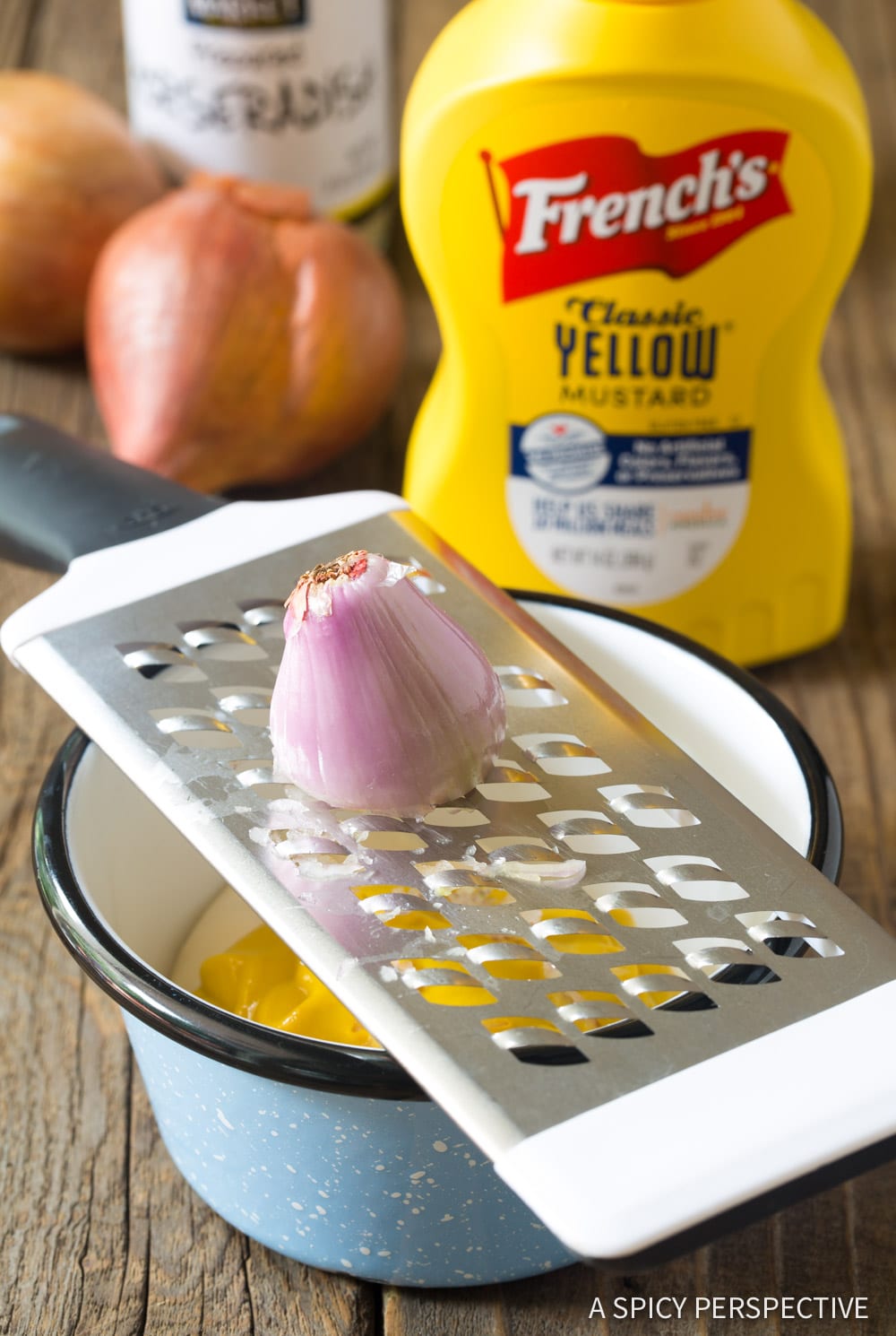 Shallot being grated into the mustard sauce. 