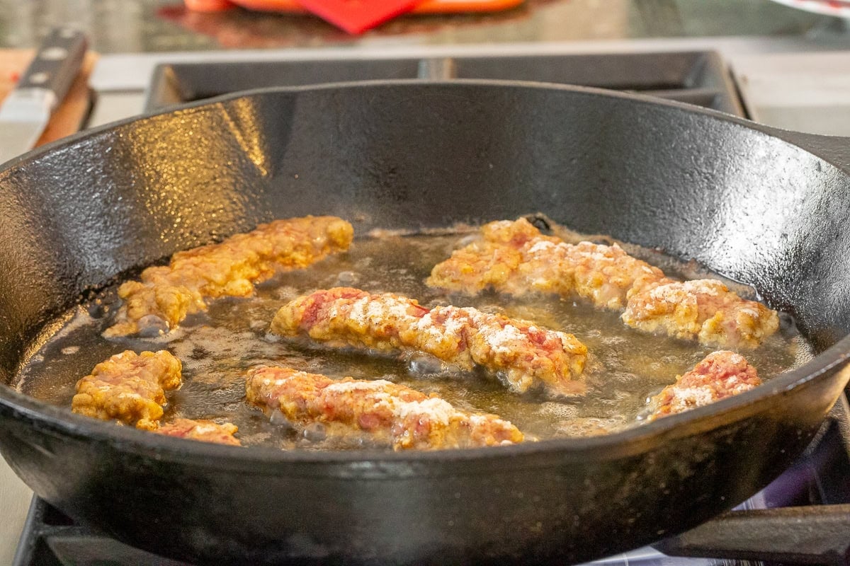 Frying steak fingers in a cast iron skillet. 