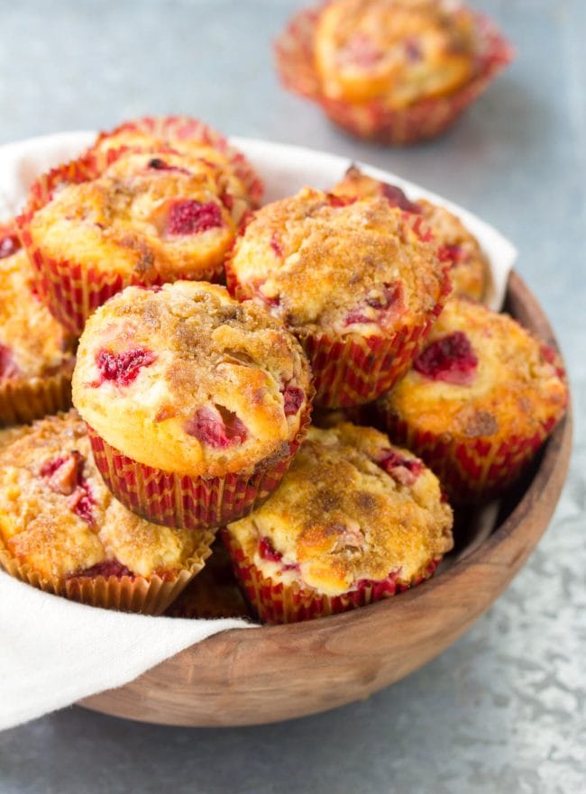 Rhubarb and strawberry muffins stacked on top of each other in a bowl. 