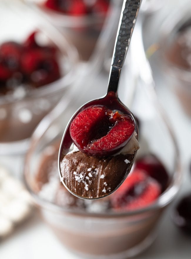 close view of spoon with pudding, cherry halve and sea salt