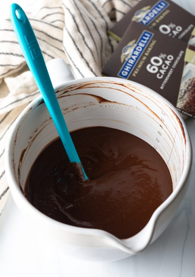 pudding with chocolate smooth mixture in a large measuring cup with blue spatula